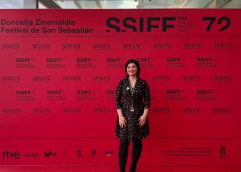 Esra Kars at the San Sebastián International Film Festival, smiling in front of the festival backdrop.